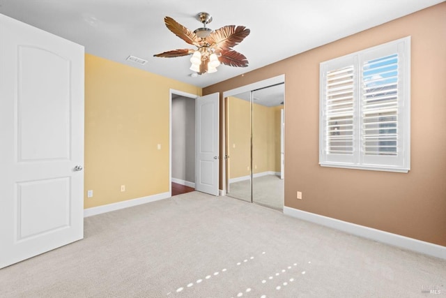 unfurnished bedroom featuring a closet, carpet, visible vents, ceiling fan, and baseboards