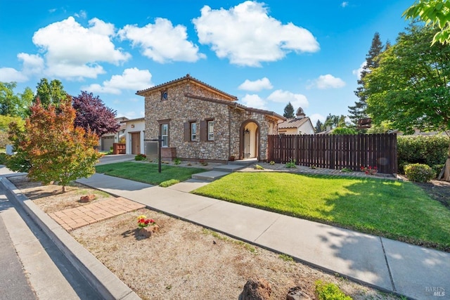 view of front facade with fence, a garage, stone siding, and a front yard