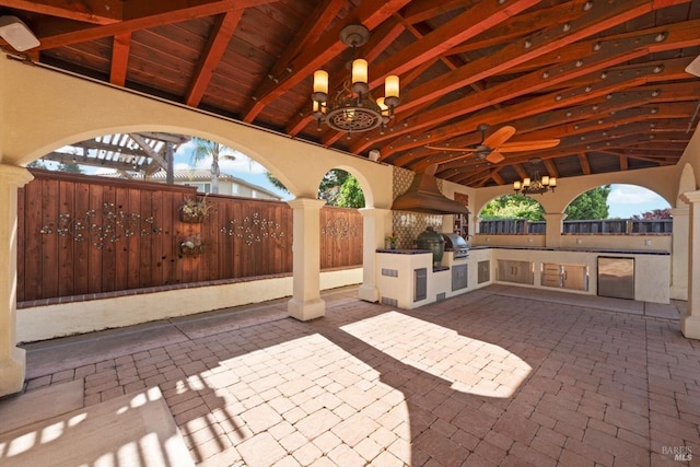 view of patio featuring fence, an outdoor kitchen, ceiling fan, and grilling area