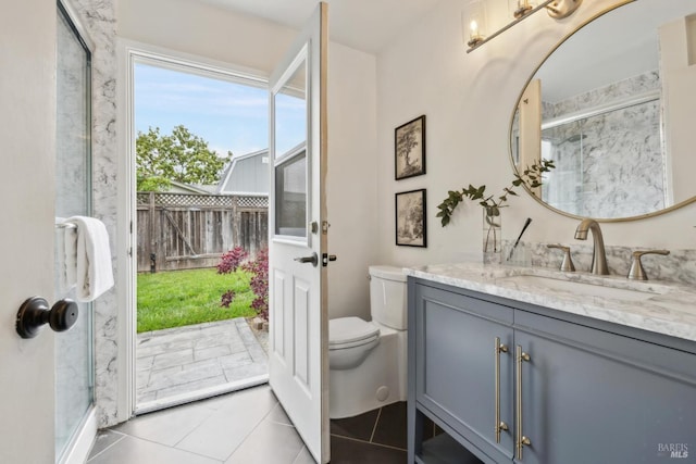 bathroom featuring vanity, an enclosed shower, tile patterned flooring, and toilet