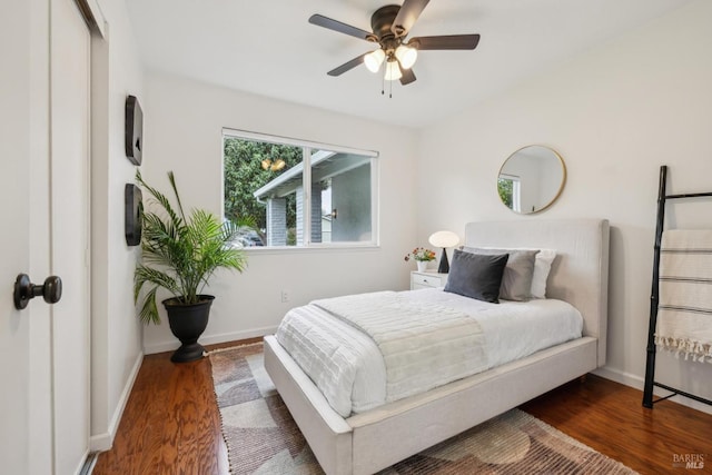 bedroom with baseboards, ceiling fan, and wood finished floors