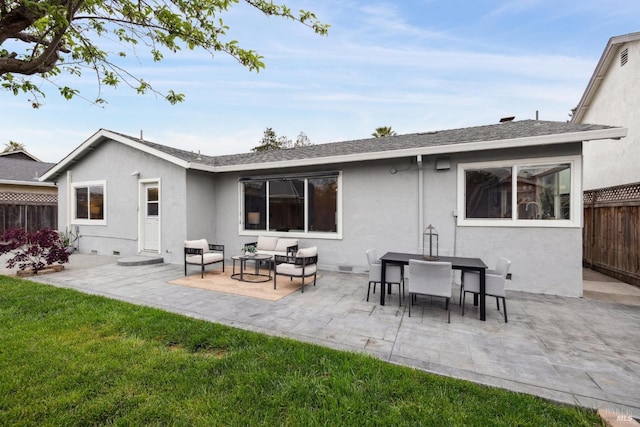 rear view of house featuring fence, stucco siding, outdoor lounge area, a patio, and a yard