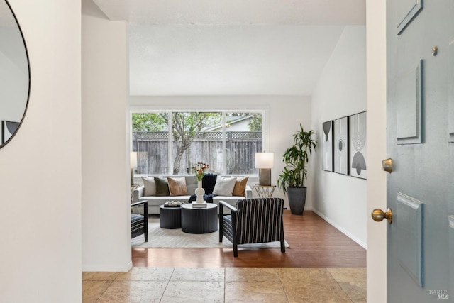 living area featuring baseboards and high vaulted ceiling