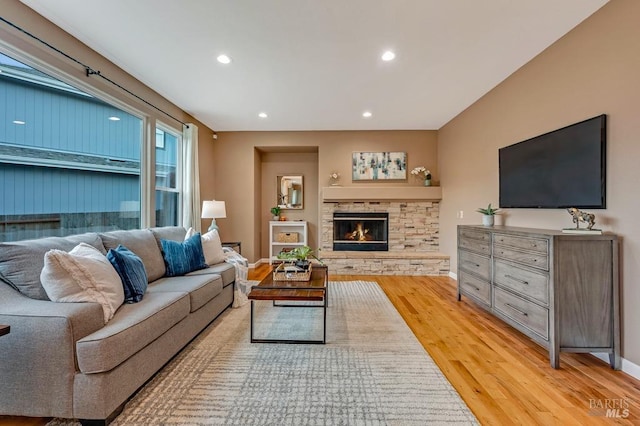 living area with recessed lighting, baseboards, light wood finished floors, and a fireplace