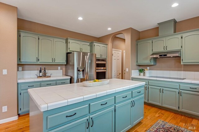 7580 Meadowlark Dr, Sebastopol, CA 95472 - kitchen with stainless steel appliances, under cabinet range hood, light wood-type flooring, tile countertops, and recessed lighting