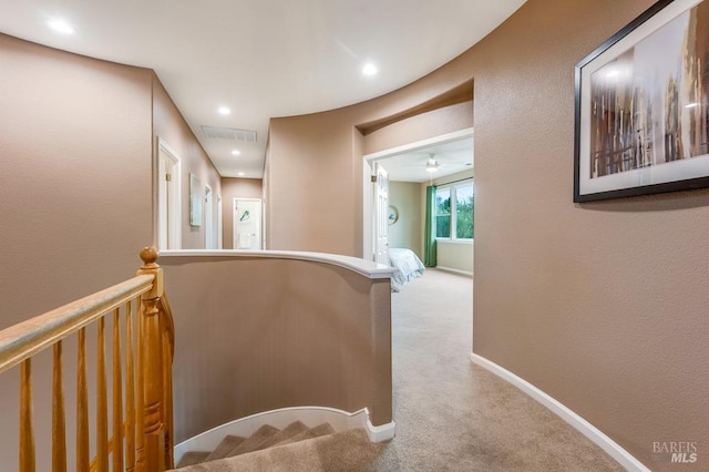 corridor with visible vents, baseboards, an upstairs landing, carpet, and recessed lighting