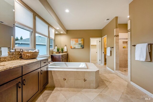 bathroom featuring a walk in shower, tile patterned floors, two vanities, visible vents, and a bath