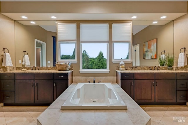 full bathroom featuring a sink, tile patterned floors, and a garden tub