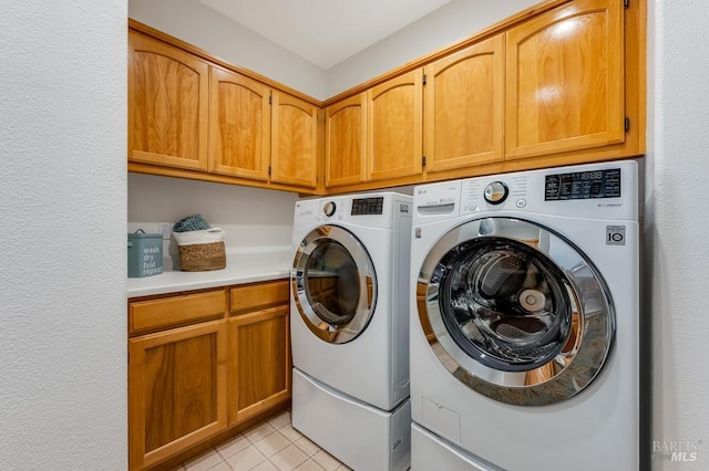 laundry area with light tile patterned floors, washing machine and dryer, and cabinet space