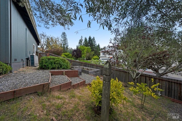 view of yard with central air condition unit, a garden, and a fenced backyard