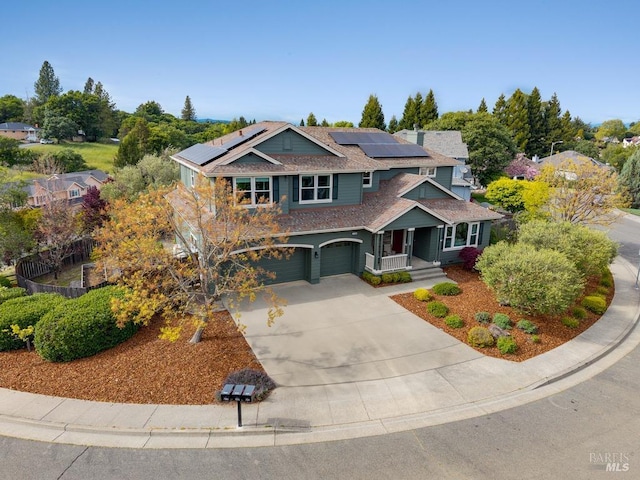 craftsman house with covered porch, concrete driveway, solar panels, and a garage