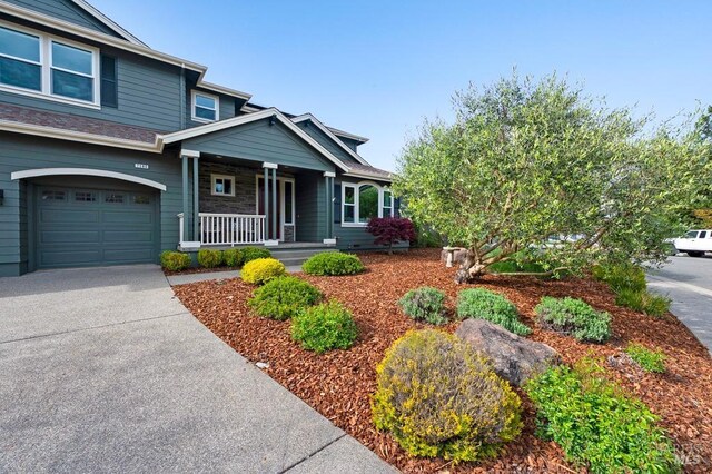 craftsman-style home featuring a garage, covered porch, and concrete driveway