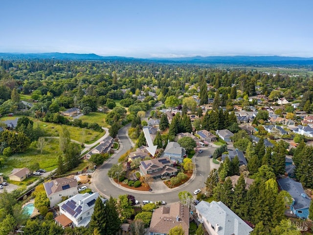 birds eye view of property with a mountain view, a residential view, and a forest view