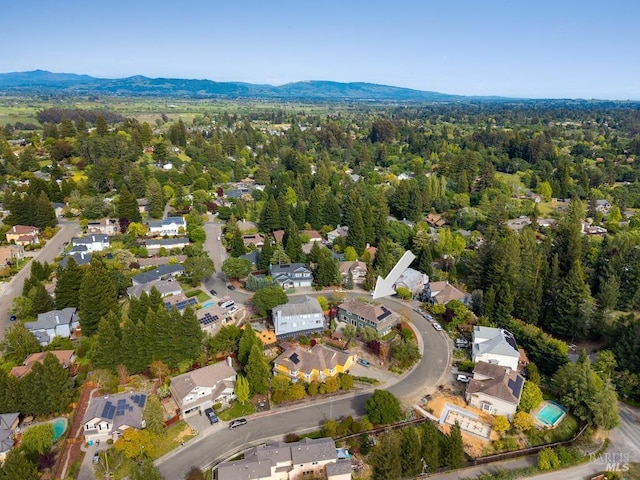 drone / aerial view with a wooded view, a residential view, and a mountain view