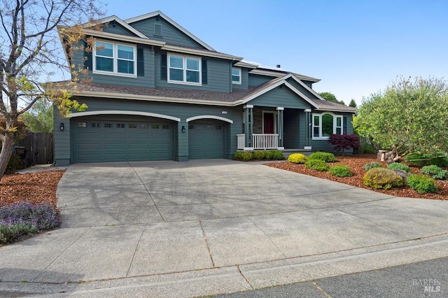 view of front of property featuring a garage, fence, covered porch, and concrete driveway