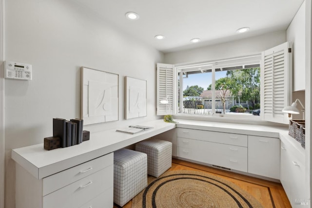 home office with light wood-style floors, recessed lighting, and built in study area