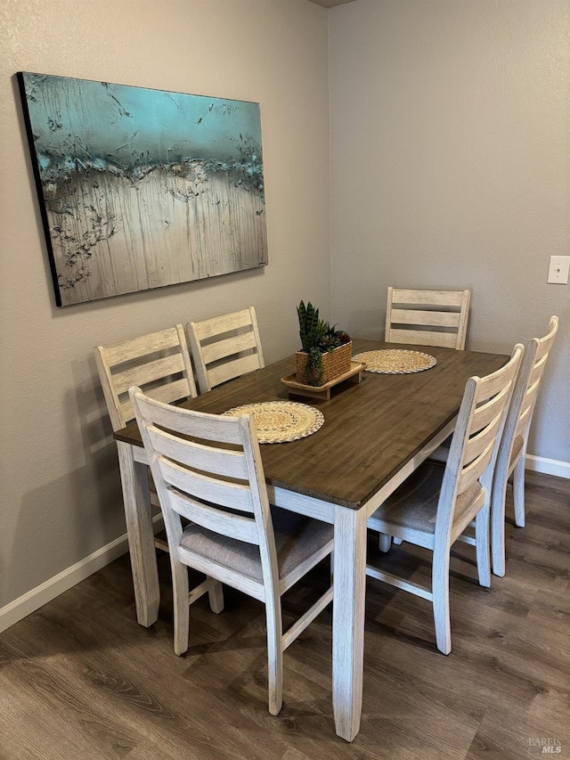 dining area with baseboards and wood finished floors