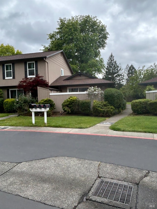 view of front of property featuring fence and a front lawn