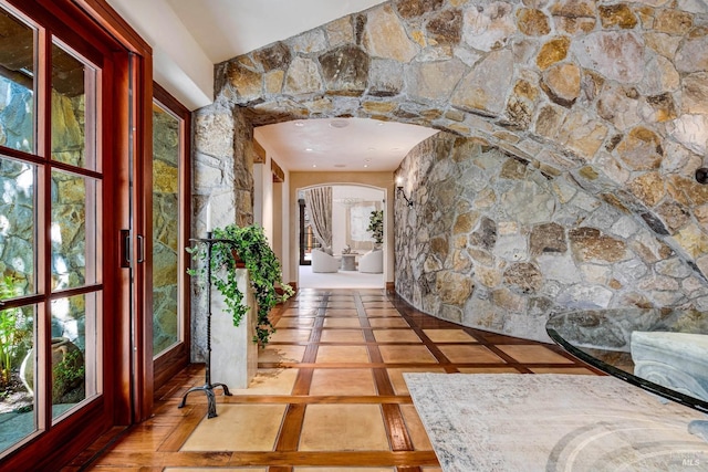 hallway with arched walkways and a wealth of natural light