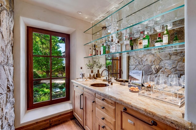 bar featuring indoor wet bar, a sink, and light wood-style floors