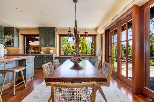 dining room featuring wood-type flooring, recessed lighting, and a notable chandelier