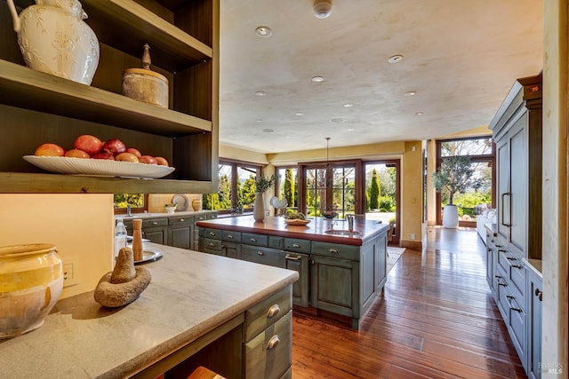 kitchen featuring a center island, plenty of natural light, open shelves, and dark wood-type flooring