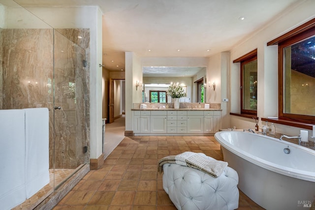 full bath with double vanity, a shower stall, recessed lighting, and a freestanding bath