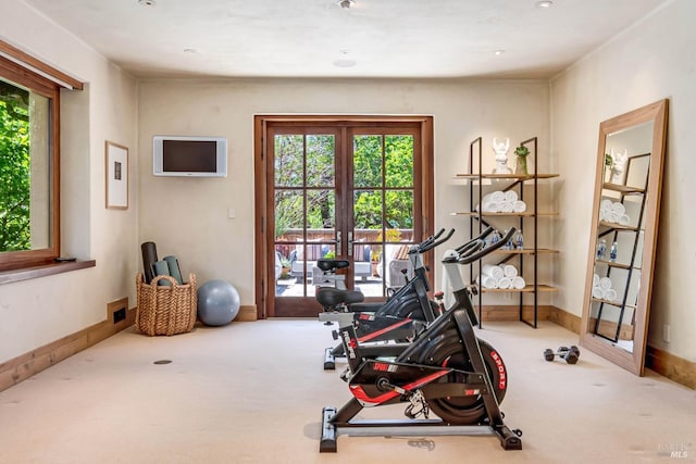 exercise room with carpet floors, baseboards, and french doors