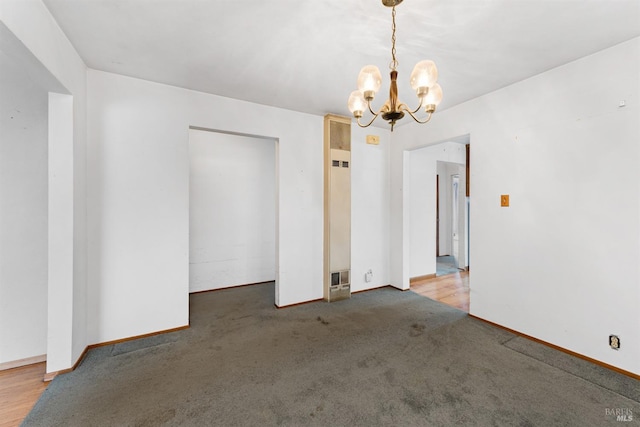 unfurnished room with baseboards, carpet, and a notable chandelier