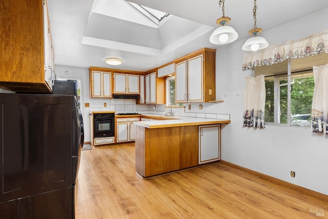 5320 Mcfarlane Rd, Sebastopol, CA 95472 - kitchen with fridge, a skylight, a peninsula, black oven, and light countertops