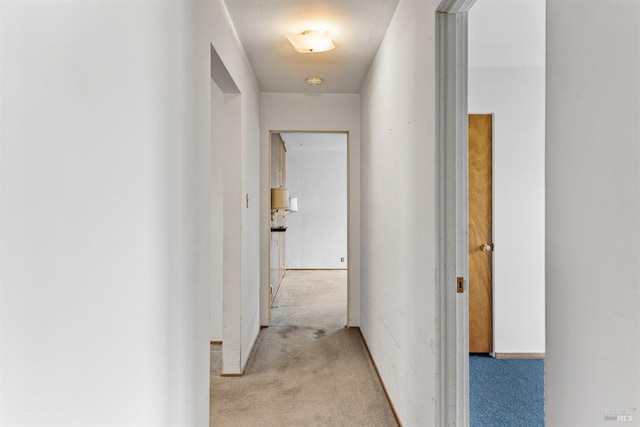corridor featuring light colored carpet