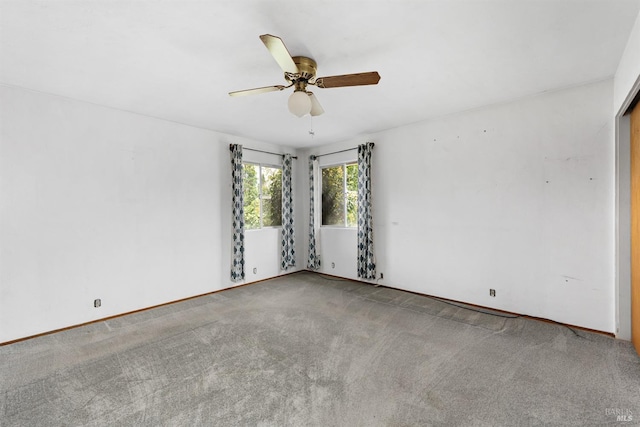 unfurnished room with carpet flooring, ceiling fan, and baseboards