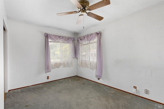 carpeted empty room featuring a ceiling fan and baseboards