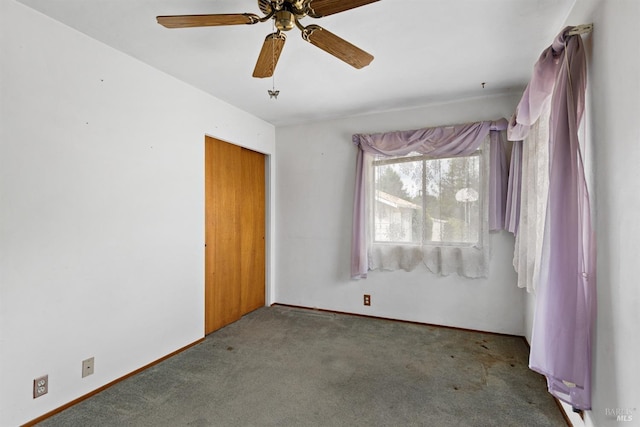 spare room featuring carpet floors, ceiling fan, and baseboards
