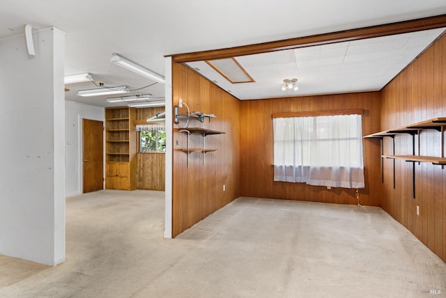 unfurnished living room featuring carpet floors and wood walls