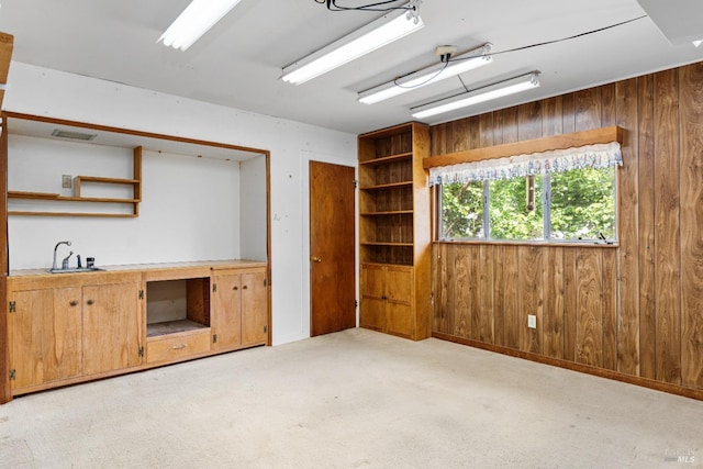 interior space featuring wooden walls and light colored carpet