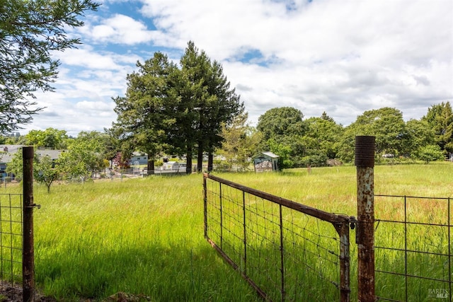 view of yard featuring a rural view and fence