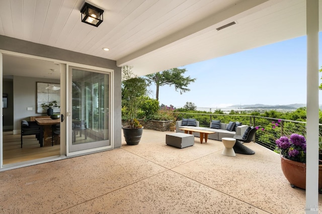 view of patio featuring a mountain view, outdoor lounge area, and a balcony
