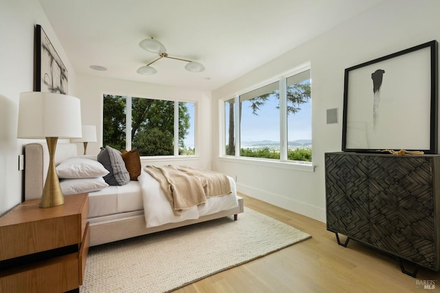 bedroom featuring light wood-style floors and baseboards