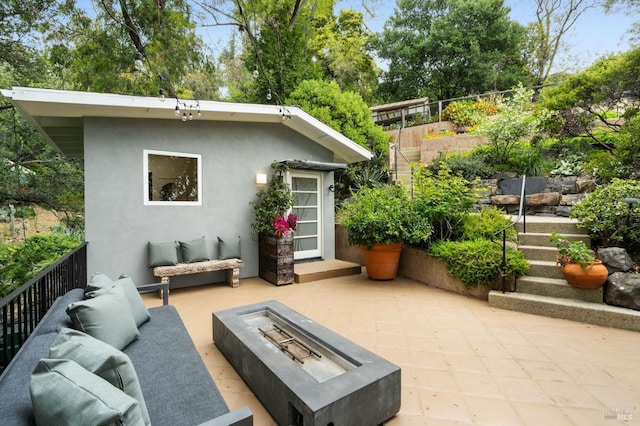view of outdoor structure with an outdoor living space with a fire pit