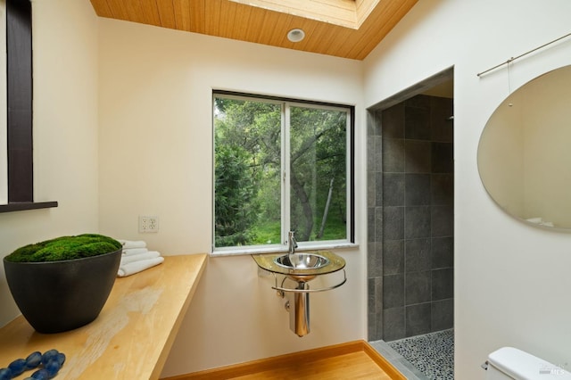 full bathroom featuring toilet, a skylight, walk in shower, and wood ceiling