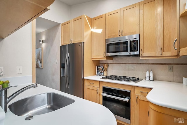 kitchen featuring a sink, decorative backsplash, light brown cabinets, and stainless steel appliances