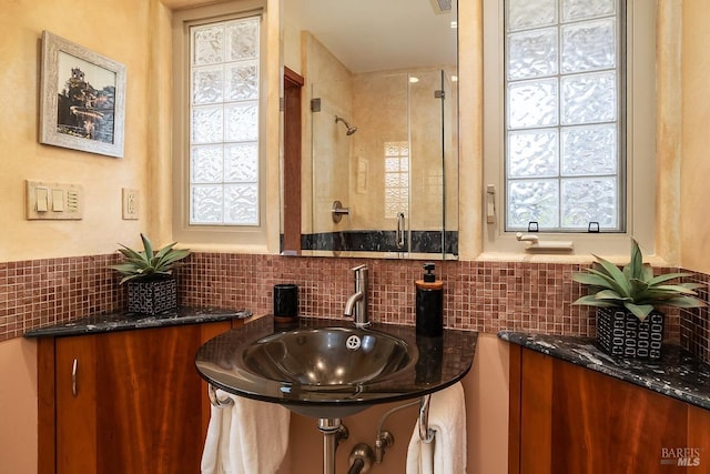 bathroom with visible vents, a sink, a stall shower, and tasteful backsplash