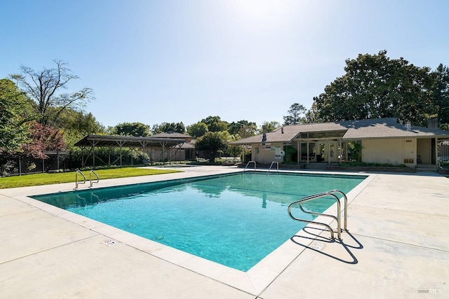view of swimming pool featuring a lawn, fence, a patio area, and a fenced in pool