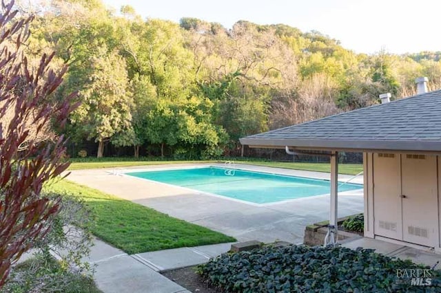 outdoor pool featuring a view of trees