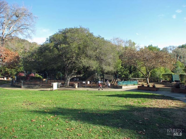 view of property's community with a lawn and a vegetable garden