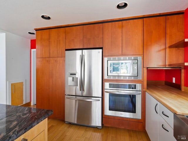 kitchen featuring light wood-style floors, recessed lighting, dark stone countertops, and stainless steel appliances