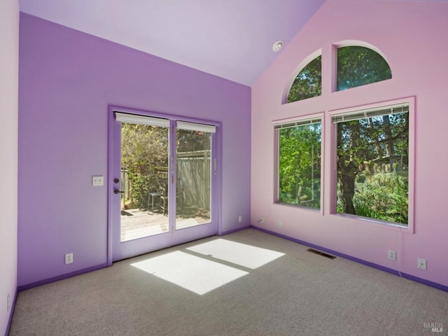 empty room with baseboards, carpet, high vaulted ceiling, and visible vents