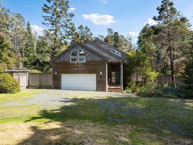 rustic home with gravel driveway, fence, a front yard, and a garage