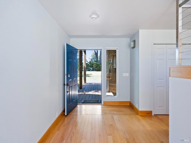 entryway with baseboards and light wood-style flooring